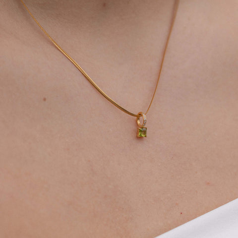 Elegante PURELEI Kette mit schwarzem Anhänger und funkelndem Detail, getragen am Hals.