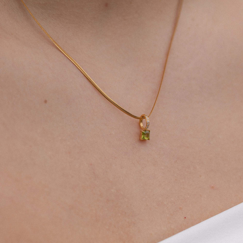Elegante PURELEI Kette mit schwarzem Anhänger und funkelndem Detail, getragen am Hals.