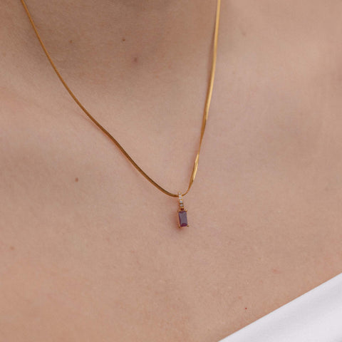 Schlichte PURELEI Kette mit schwarzem Anhänger, elegant am Hals getragen.