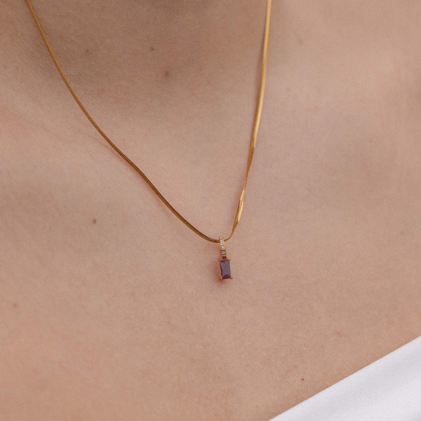 Schlichte PURELEI Kette mit schwarzem Anhänger, elegant am Hals getragen.