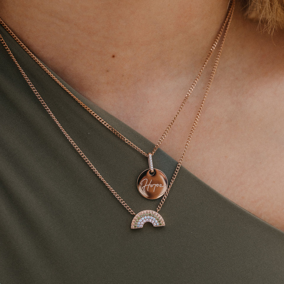 Zwei roségoldene Ketten mit Anhängern Hope und Regenbogen von PURELEI, elegant und inspirierend.