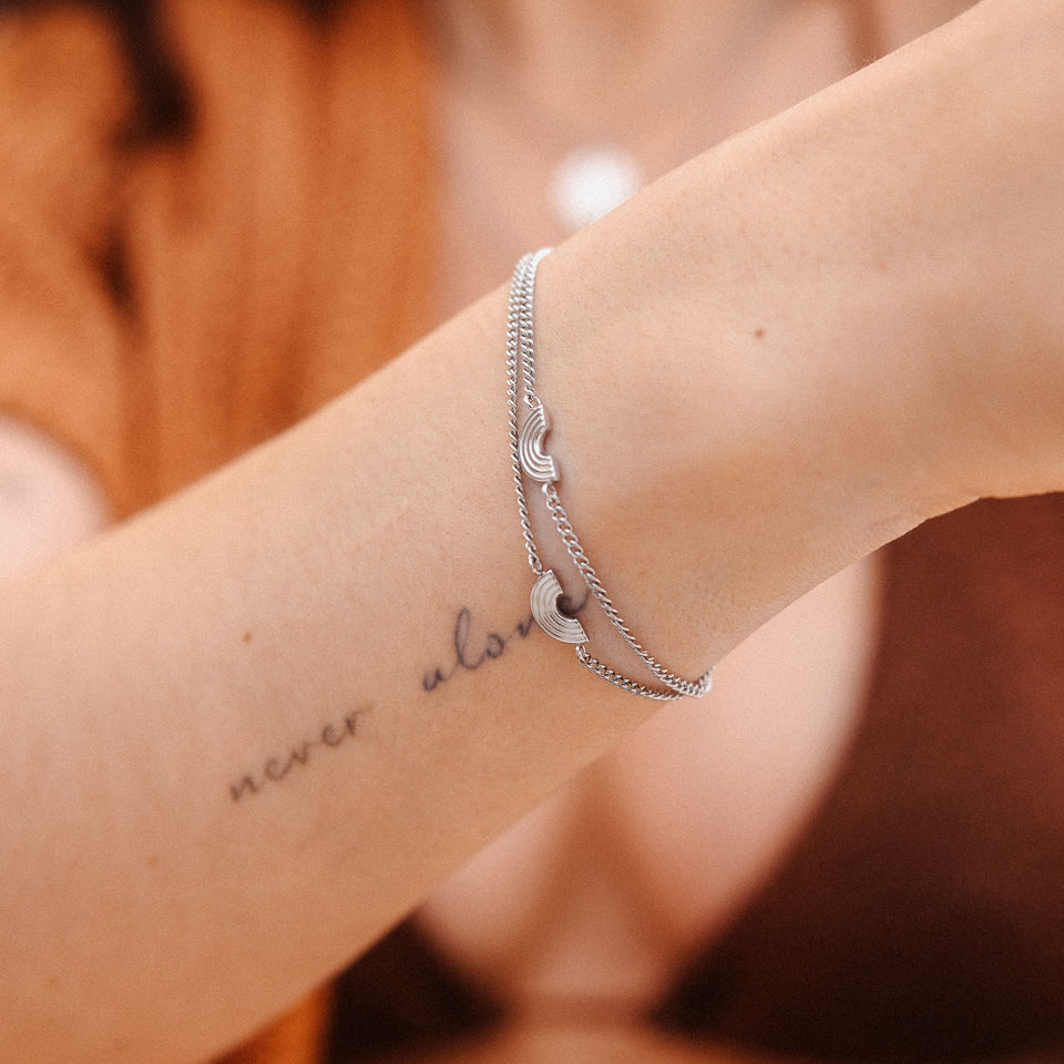 Silbernes Armband mit Wellen-Design, getragen am Handgelenk, PURELEI inspiriert.