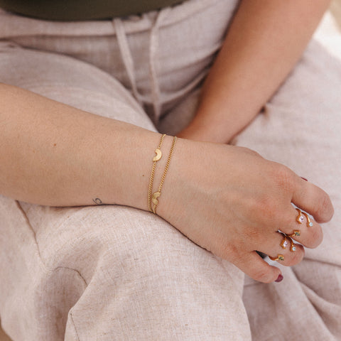 Roségoldenes Armband mit Mondmotiven, getragen am Handgelenk, PURELEI.