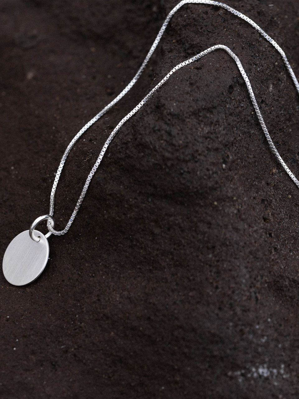 PURELEI Perfection Kette aus recyceltem Silber mit gravierbarem Charm auf dunklem Lavastein, zeitlos elegant.