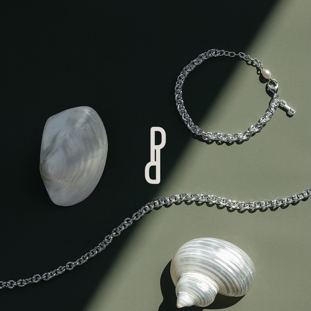 Silberne Kette mit Kreuzanhänger auf dunklem Hintergrund, inspiriert von PURELEI.