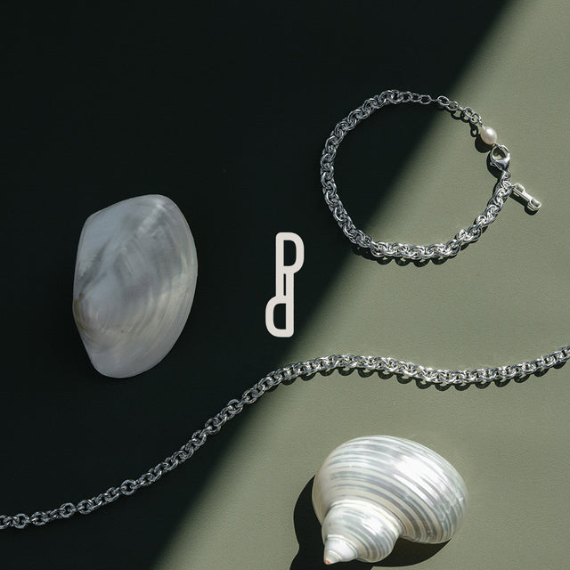 Silberne Kette mit Kreuzanhänger auf dunklem Hintergrund, inspiriert von PURELEI.