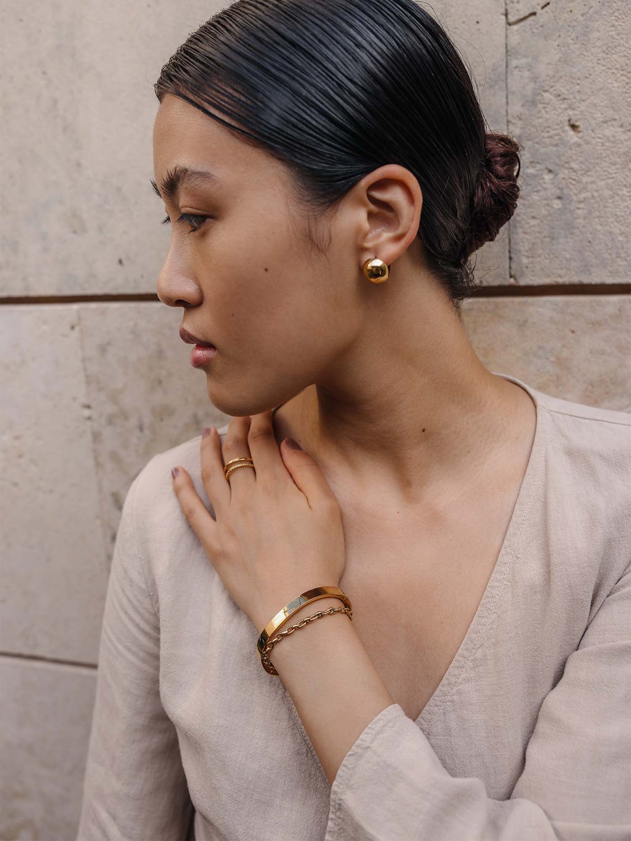 Elegante goldene Ohrringe und Armband von PURELEI, getragen in minimalistischer Atmosphäre.