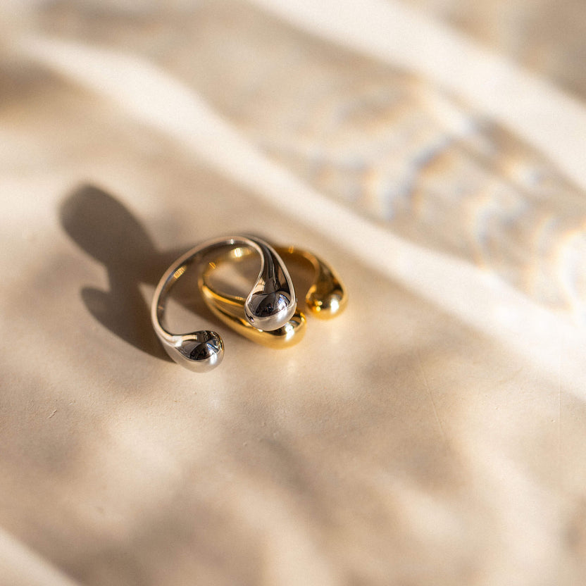 Silberne Ringe mit geschwungenem Design auf sanftem Stoff, PURELEI inspiriert.