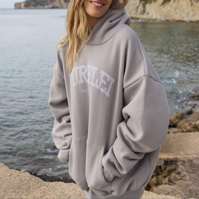 Beige PURELEI Hoodie mit Kapuze, lässig am Strand getragen, entspannte Stimmung.