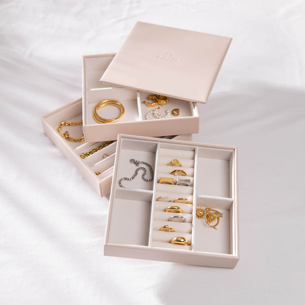 Schmuckaufbewahrung 3er-Set aus beigem Kunstleder mit PURELEI-Logo, elegant und stapelbar für feinen Schmuck.